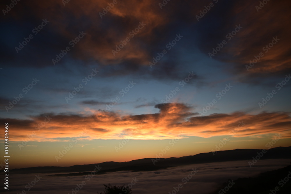 Fototapeta premium stunning view of a sunrise between fog ans sky