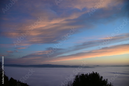 stunning view of a sunrise between fog ans sky