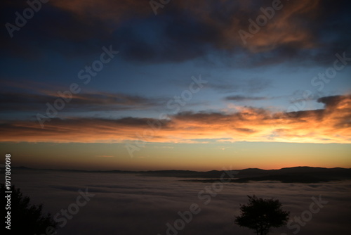 stunning view of a sunrise between fog ans sky
