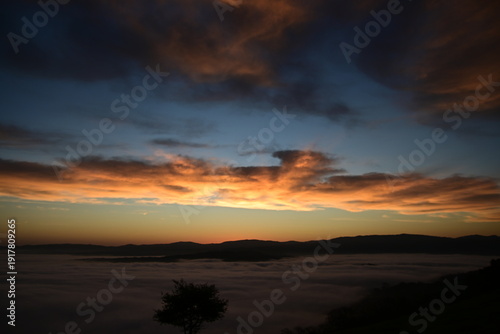 stunning view of a sunrise between fog ans sky