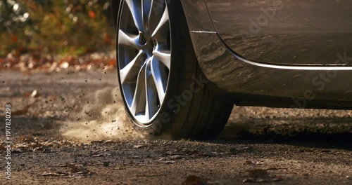 Slow Motion Close Up Of Car Wheel Spinning With Dust And Smoke. Power And Motion Concept