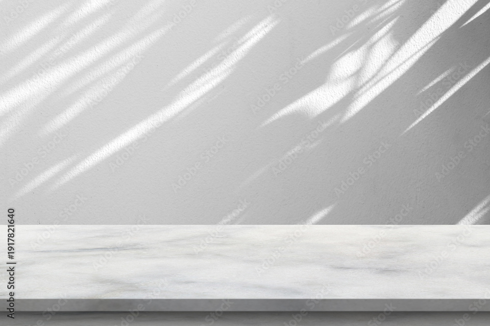 Obraz premium White marble stone podium on grey wall background with natural leaf shadows for product presentation mockup