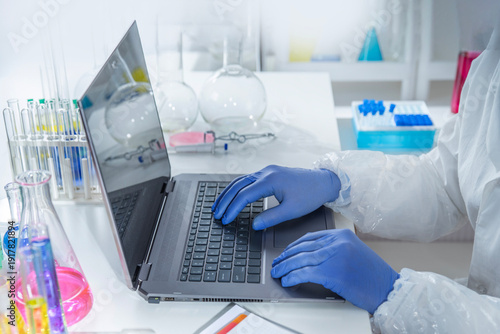 Photography Experienced professor recording experimental data on a laptop while working in a laboratory