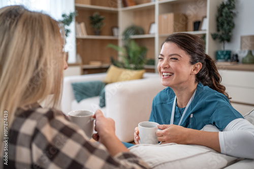 Tablou pe pânză Caregiver and patient bonding over shared coffee break and laughter