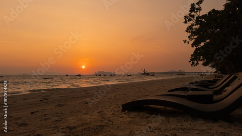 Boats in silhouette on beach during vibrant sunset