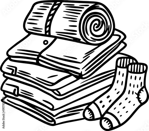 Stack of folded clothes with rolled blanket and pair of socks, laundry or storage concept