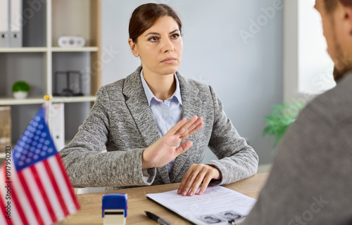 Bild auf Leinwand Immigration denial and rejection by consulate officer showing refusal gesture to applicant during visa interview