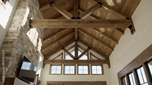 Interior architectural detail with exposed wood beams vaulted ceiling and stone accent wall in modern luxury home