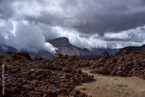 Mount Guajara through storm clouds above lava field