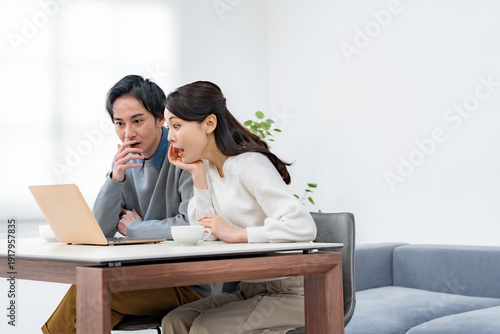Foto パソコンを見て驚く男女