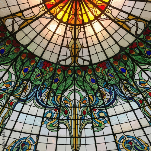 The intricate design of the stained glass ceiling and windows within the Galleria Vittorio Emanuele II in Milan showcases classic Italian architecture and artistic patterns