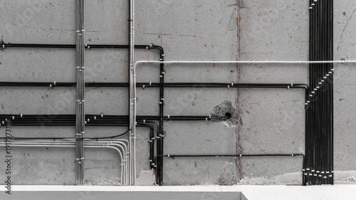 electrical installation work, cable laying. perfect wiring of cables on the ceiling. straight perpendicular lines. professional electrician, concrete slab, black and white cables, repair