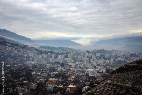 Scenic panorama of Gjirokaster town by misty evening, Albania