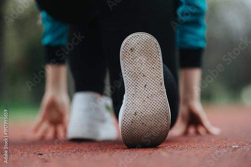 Fotografie Runner's shoe is in focus as they prepare to start on a track
