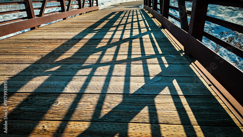 Fotografija footbridge with a wooden plank deck and steel railings