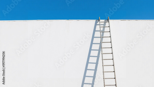 Ladder against a white wall reaching for a bright blue sky