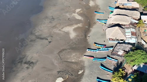 Fishing boats lined up on the shore in a coastal area