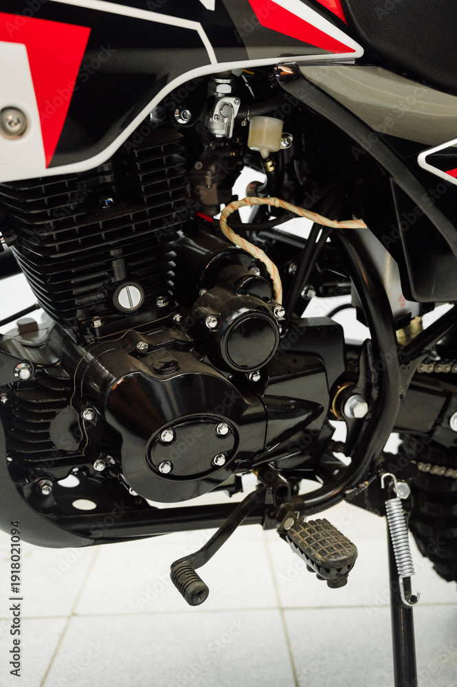 Obraz premium Detailed view of the motorcycle engine with chrome exhaust pipe.