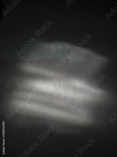 Fényképezés Dramatic Sunlight Beam and Sharp Shadow on Gray Textured Wall Background