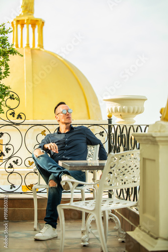 A man is sitting on a chair in a hotel