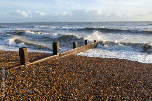 Waves crashing against groyne on shingle beach, Bexhill-on-Sea, East Sussex, England, United Kingdom, Europe