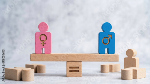 Pink female and blue male wooden figures standing perfectly on balance scale representing gender equality and fairness concept with harmony showing equal rights