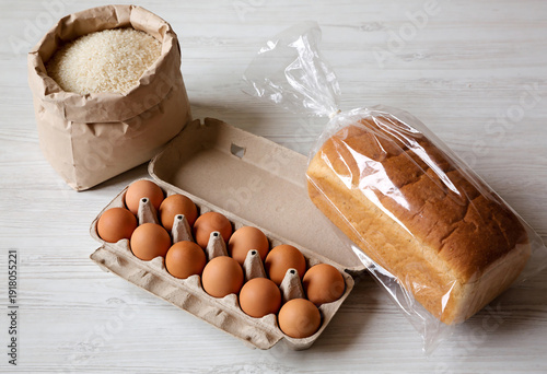 Basic Food Staples: Rice, Eggs, and Bread on Wooden Surface