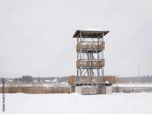 Fotografie Observation tower standing in a snowy wetland area near the Narva River on a quiet winter day