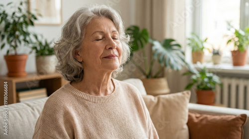 Elderly woman doing breathing exercises while relaxing on sofa at home  