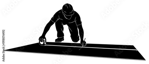 Silhouette of a construction professional measuring a surface with a tape measure on site