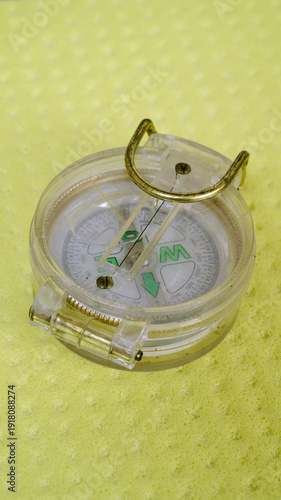 little scout plastic compass isolated on yellow background