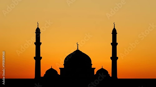 Silhouette of a mosque against a vibrant orange sunset sky, showcasing its iconic domes and minarets