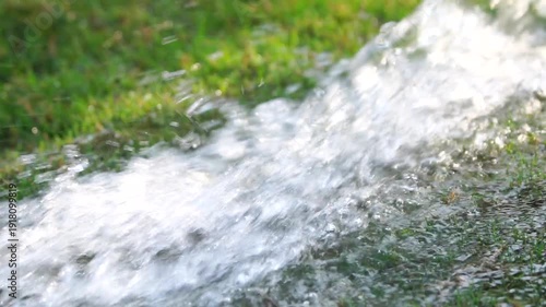 Water flowing over grass in a natural landscape during daylight in native habitat range slow-motion