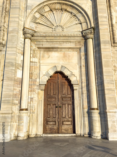 Foto Ornate wooden double doors framed by intricate stone archway and decorative elem