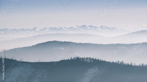 Schilderij op canvas Panoramic winter mountain landscape with distant Tatras peaks and layered ridges in Beskid Zywiecki, Poland