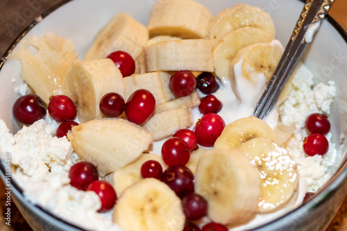 Cottage cheese mixed with bananas and cranberries in a bowl. Healthy eating
