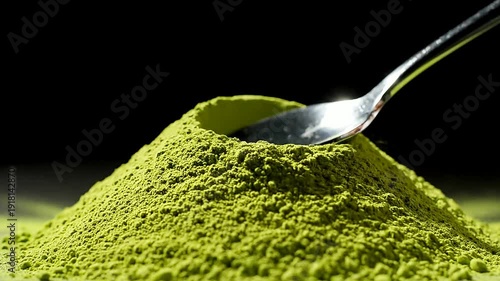 Close up of green powder with spoon in studio or Macro of green powder pile under spoon in studio