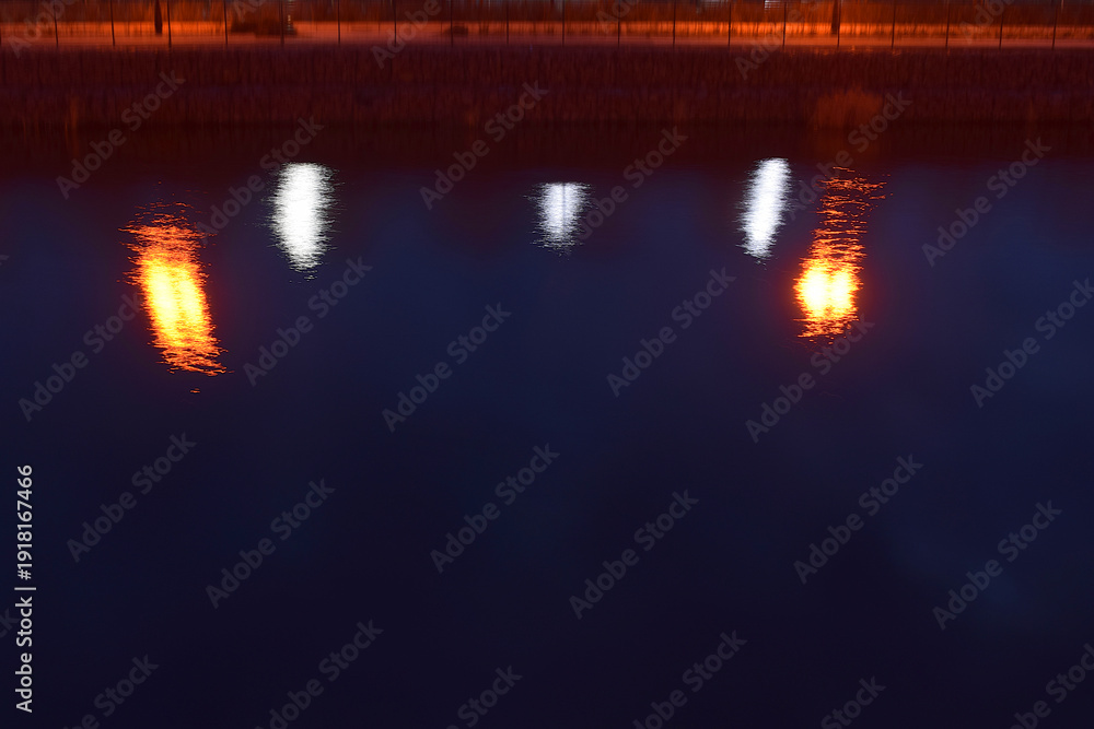Obraz premium Reflection of lights on the embankment in the water at night.