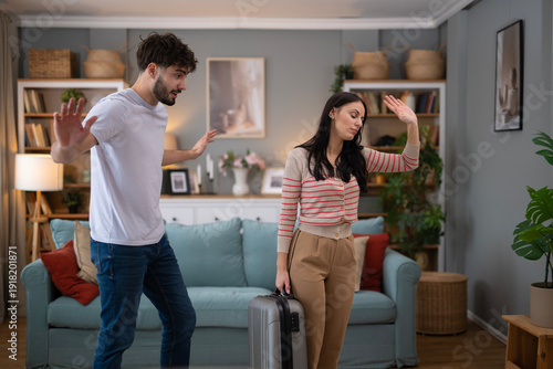 Foto Couple having conflict, woman leaving with suitcase