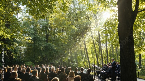 A group gathers to listen to classical music played by musicians under the shade of green trees in a sunny forest clea at an outdoor summer concert spot.