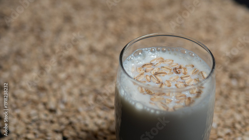 Oat Milk in Glass with Oat Grains on Top, Plant Based Milk Concept