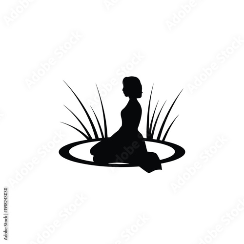 Silhouette of a woman meditating amidst tall blades of grass