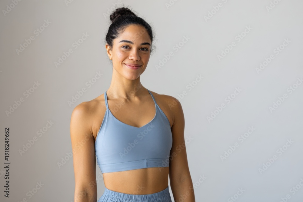 Fototapeta premium Young hispanic female in sportswear smiling confidently indoors