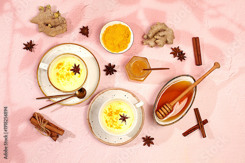 Photos Golden turmeric latte with ginger, cinnamon, anise and honey spices on sunny table