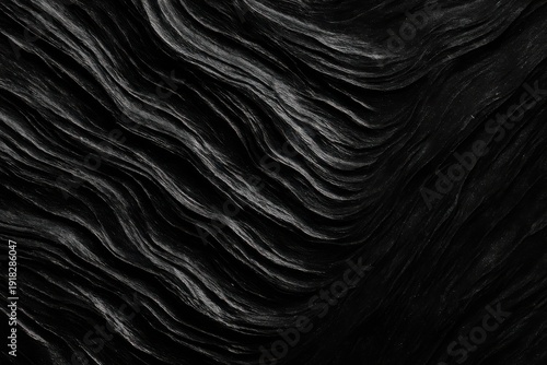 Abstract black mineral surface showing dramatic flowing geological strata layers