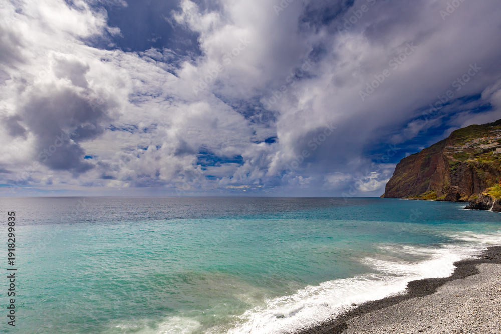 Obraz premium Azure water of the Atlantic Ocean under a cloudy sky, Madeira Island, Portugal, nature background or travel wallpaper