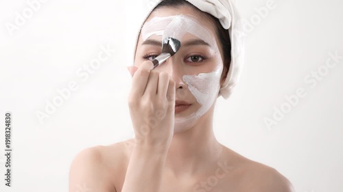 Wallpaper Mural Beauty concept of 4k Resolution. Asian woman is applying a cream mask to her face on a white background. Torontodigital.ca