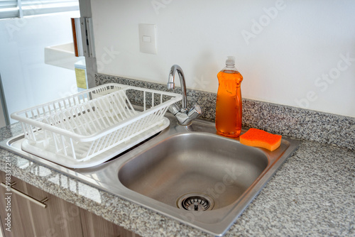 Clean kitchen sink with dish rack and soap dispenser