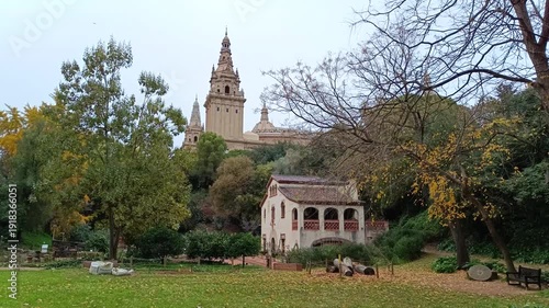 Distant view of the National Palace of Montjuic from a lush green garden in Barcelona