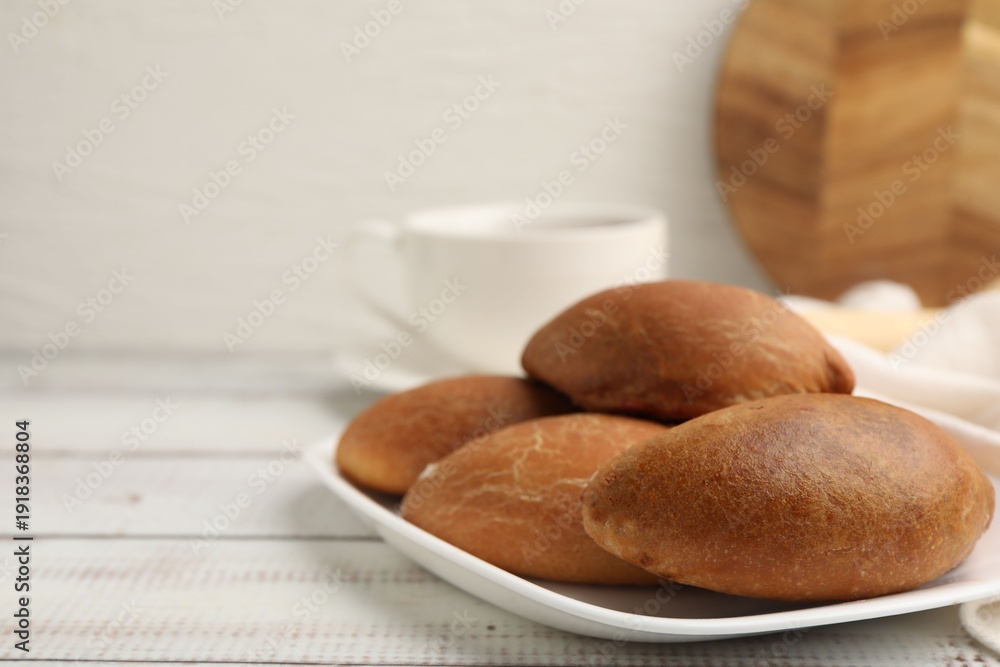 Fototapeta premium Yummy baked patties served with tea on white wooden table, closeup. Space for text